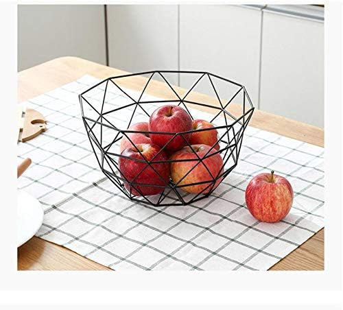 Panier à fruit en métal posé sur une table avec des pommes à l'intérieur