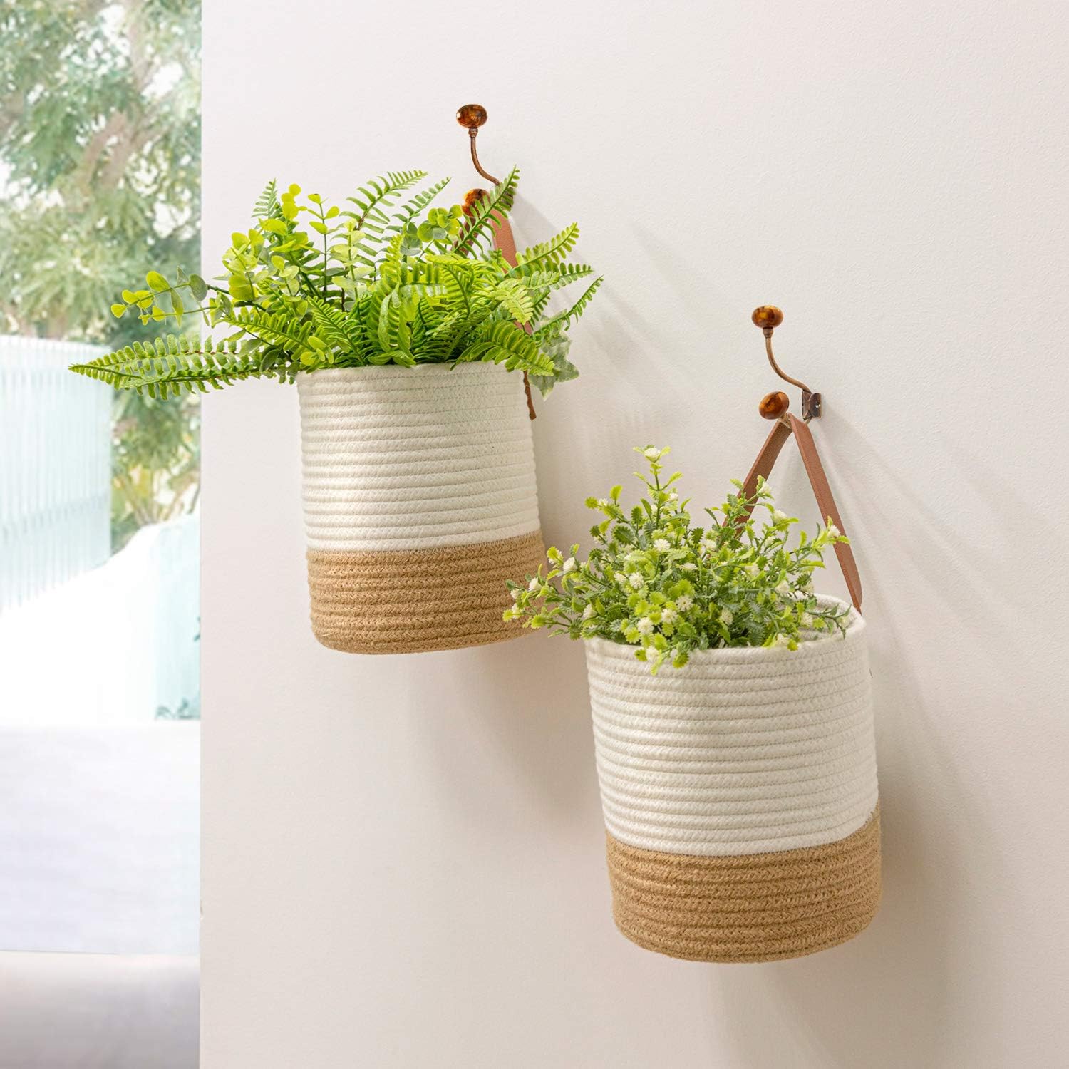 Panier suspendu blanc en jute avec des plantes à l'intérieur