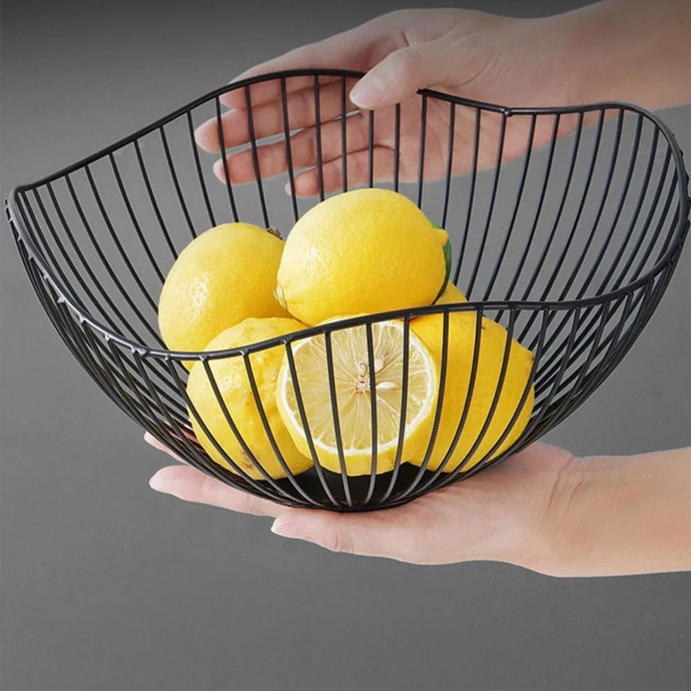 Panier à fruit en métal noir avec des citrons à l'intérieur