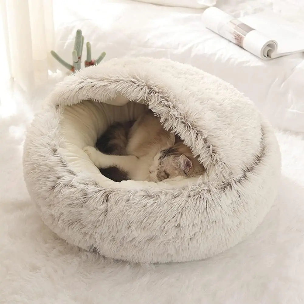 Panier confortable avec couvercle pour chat posé sur un tapis blanc